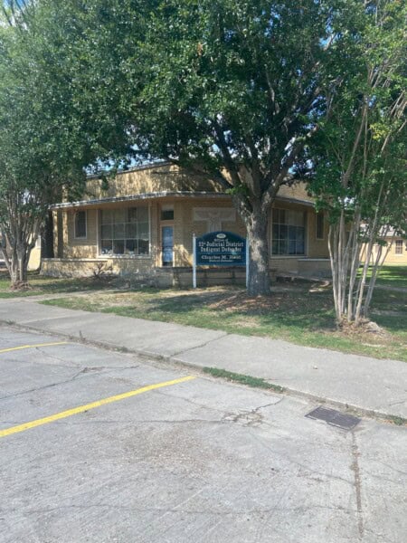A single-story brick building with a visible sign reading "Fuller Therapy Services" stands proudly, nestled among trees near the Louisiana State Public Defender's Office. A convenient parking area is situated in front for easy access.
